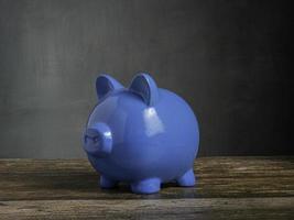 blue piggy on wood table for earn or saving concept photo