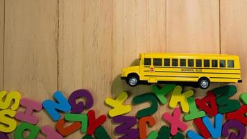 el alfabeto de madera multicolor y el autobús escolar en la mesa para la educación o el concepto de niño foto