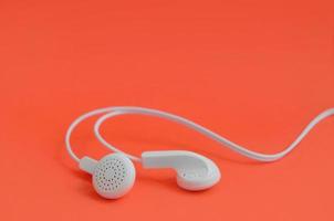 una plantilla para fanáticos de la música. auriculares blancos sobre rojo foto