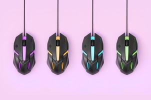 Black computer mouses hang on pastel pink background photo