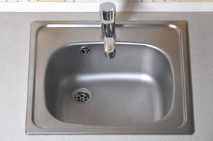 Sink with silver faucet. New equipment in kitchen counter photo