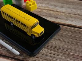 autobús escolar en tableta para educación o concepto de aprendizaje electrónico foto