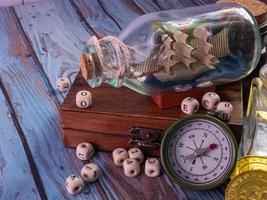 boat in  bottle on wood table for travel or transport concept photo