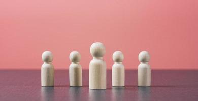 Wooden dolls lined up on the table, the concept of effective personnel management in the organization, the position and ability of the person. photo