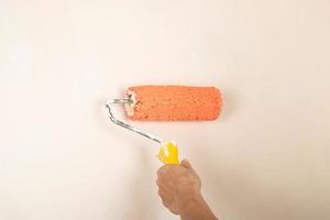 paint roller in the worker's hand on the background of the wall photo