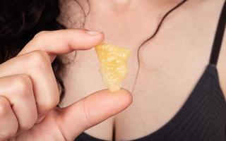 girl holding a piece of wax with a high content of THC in her hands photo