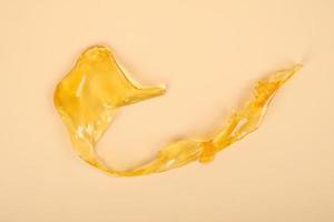 high thc, cannabis wax marijuana concentrate on yellow background macro photo