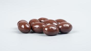 chocolate nuts on gray background, chocolate coated peanuts photo