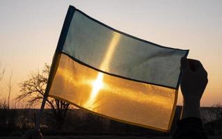 yellow-blue flag of ukraine over ukrainian sunset sky photo