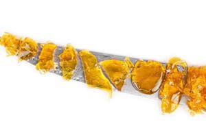 cannabis wax with a high content of thc on the blade of a knife isolated on a white background photo