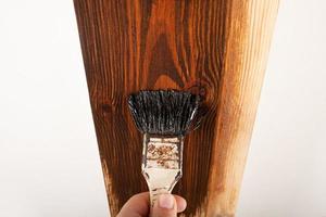 varnishing a doorway, applying varnish with a brush on a wooden surface photo