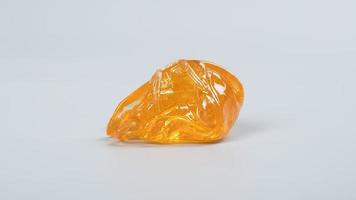 piace golden dab concentrate of cannabis wax close up on gray background, marijuana resin photo
