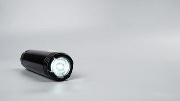 led flashlight on gray background with copy space photo