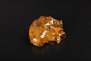 golden dab of cannabis on a dark background, high thc extract photo