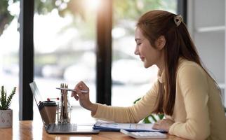 Business woman pen pointing turnover with graph chart report on laptop computer for analysis data photo