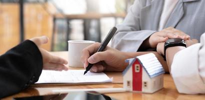 A lovely couple in the meeting with their real estate agent to sign the house contract. Property investment concept. cropped image photo