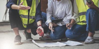 Professional Construction and Engineer team Working on workplace. Professional black architect and construction worker working look at blueprint plan on site. photo