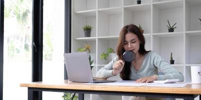 Business analyst using magnifying to review financial graphs, charts. Concept of Analyze return on investment and business analytics growth. photo