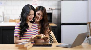 Portrait of young Asian female lovers reading book and spending happy time together, LGBT concept photo