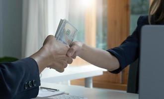 A female lawyer or business legal consultant receives a bribe or tribute from her client in the office. Corruption concept. cropped and close-up image photo