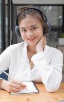 Image of a young woman studying online using a tablet. Looking at the camera. photo