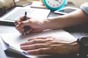 Close up of male hands writing on paper on his office desk. photo