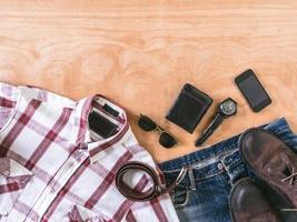 Top view of Men's casual outfits with accessories on wooden table background photo