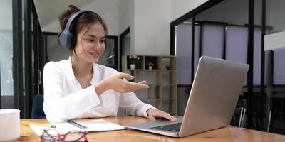 close up of Student learning online class by using laptop computer and writing notebook at workplace, E learning and online working concept. photo