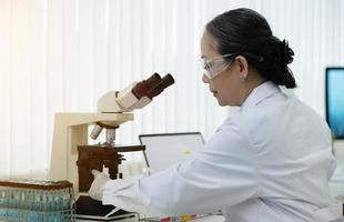 un médico que trabaja en un laboratorio de investigación mujer senior de ciencia haciendo experimentos con drogas. concepto de química, medicina, bioquímica, biotecnología. y cuidado de la salud foto