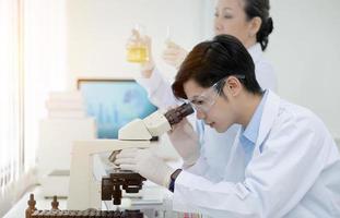 equipo científico de investigación bioquímica que trabaja con microscopio para el desarrollo de vacunas contra el coronavirus en laboratorios de investigación farmacéutica, enfoque selectivo foto