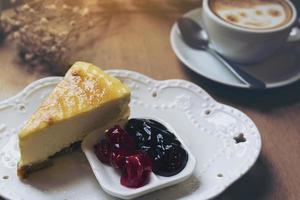 Cheese cake with hot coffee cup on wooden table