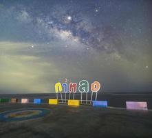The Milky Way at the sea view point, non-English text in the image is Kalong bridge and the place name badge Here will use a variety of colors like rainbow colors. photo