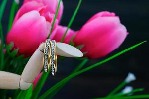 Wedding ring resting in a fake pink tulip flower photo