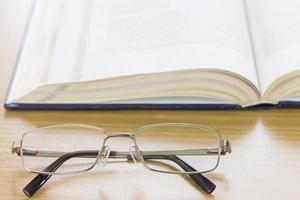 Close up glasses and a book on the desk photo