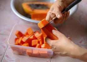 Hands slicing ripe papaya photo