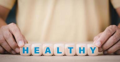 Men hold wooden blocks and display messages, healthy concepts from diet and exercise, including raw vegetable and vegetarian nutrition and focusing on healthy food and adequate rest. photo