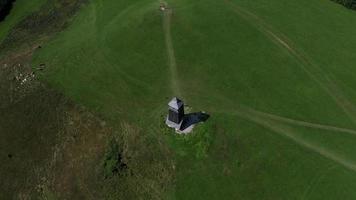 Aerial view - orbiting a watch tower on a green field video