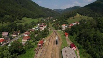 Aerial view backwards of a steam train going to station video