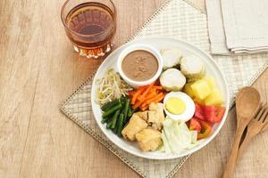 gado gado, ensalada de verduras tradicional indonesia con salsa de maní, pastel de arroz, tofu y huevo foto