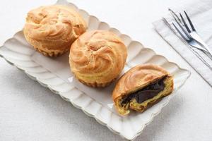 pasteles de chocolate soes, sus vla, una masa choux tradicional francesa rellena de natillas. foto