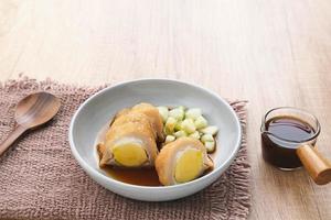 Pempek, Empek-Empek, traditional food from South Sumatra, Indonesia. This fish-based food is very popular. Served with cuko sauce and cucumber slices. photo