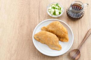 Pempek, Empek-Empek, traditional food from South Sumatra, Indonesia. This fish-based food is very popular. Served with cuko sauce and cucumber slices. photo