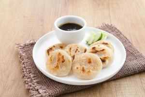 Pempek Panggang or Pempek Tunu, traditional food from South Sumatra, Indonesia. This fish-based food is very popular. Served with cuko sauce. photo