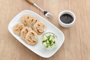 Pempek Panggang or Pempek Tunu, traditional food from South Sumatra, Indonesia. This fish-based food is very popular. Served with cuko sauce. photo