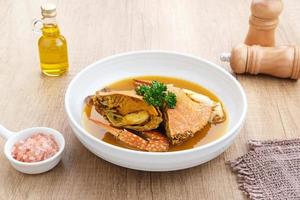 Kepiting Saus Padang, Crab with Padang Sauce, spicy and savory. Served in white bowl. photo