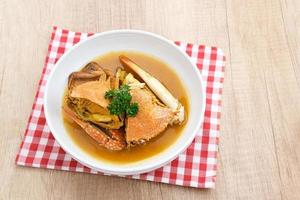 Kepiting Saus Padang, Crab with Padang Sauce, spicy and savory. Served in white bowl. photo