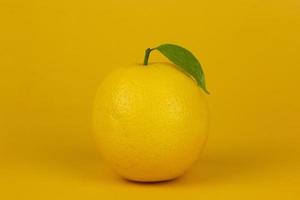 A lemon isolated on yellow background. yellow lemon for healthy fruit concept design photo
