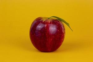 A red apples isolated on yellow background. Organic red apple fruit used for healthy fruit concept  with clipping path and full depth of field photo