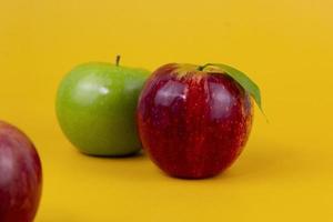 Red and green apples isolated on yellow background. Two fresh apples fruits usedd for healthy food concept and for diet apples photo