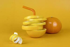 Lemon fruit slice in layers with peels and juicy orange isolated on yellow background. Juicy lemon sliced for fruits advertising design photo